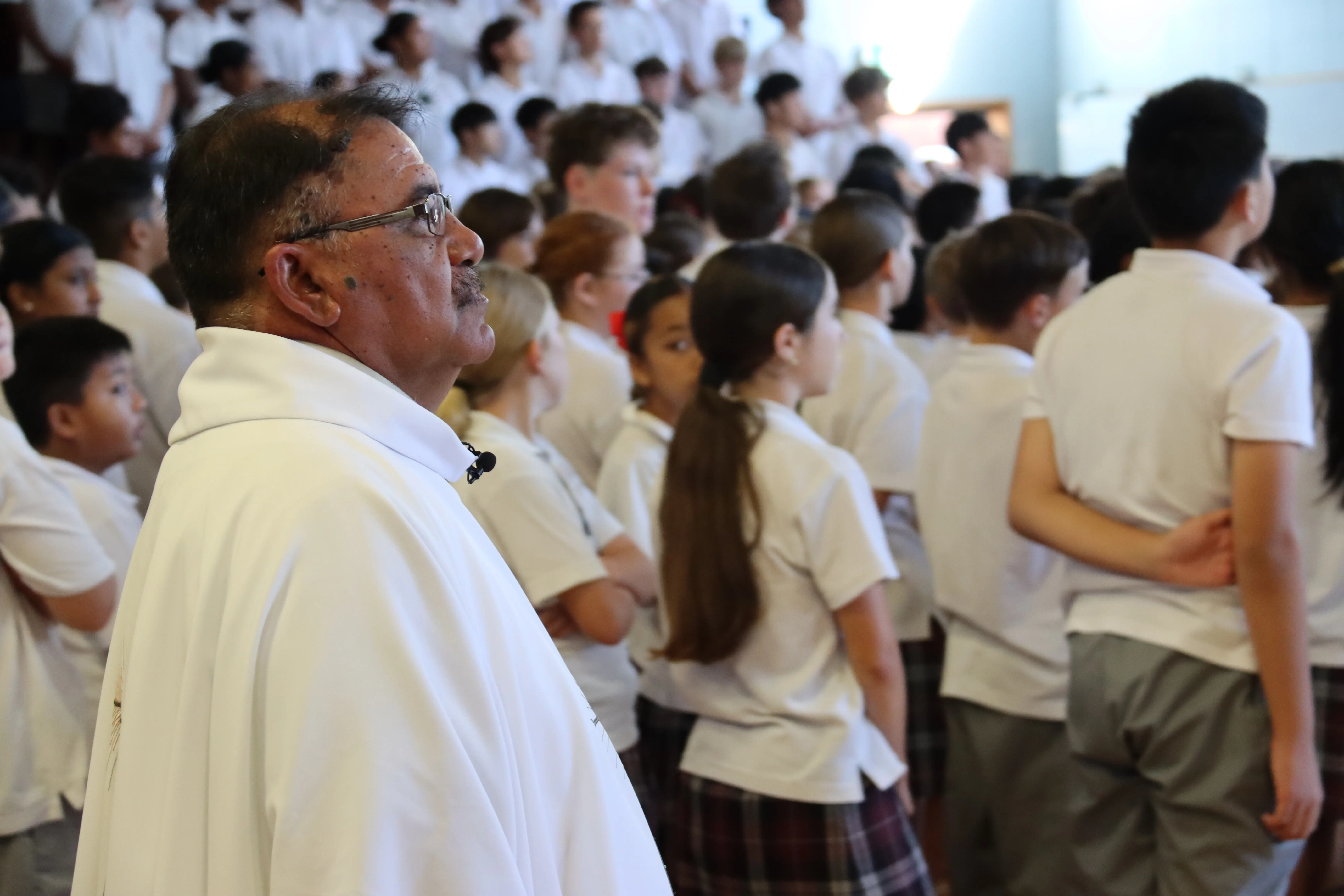Image of the Preist with students at Investiture Mass