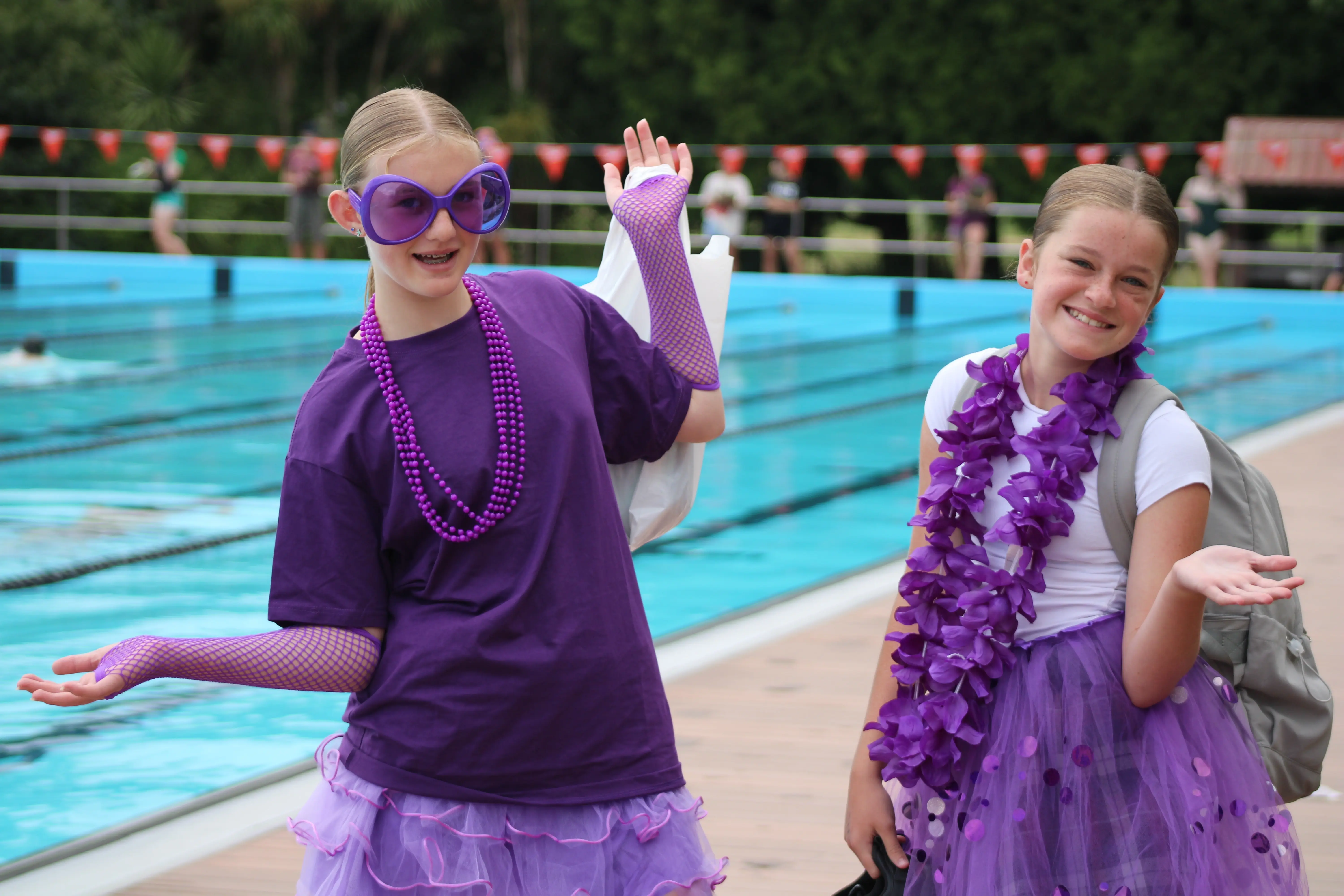 Image of two girls dressed in purple smiling at the camera